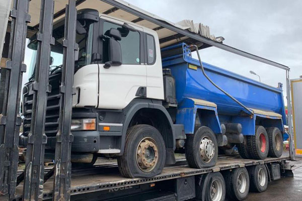 Tipper Truck being transported on a flatbed trailer